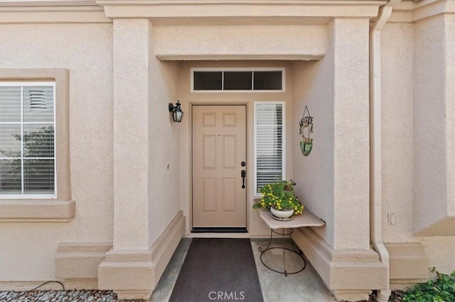 view of exterior entry featuring stucco siding