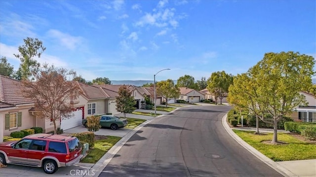 view of street with curbs, a residential view, and street lights