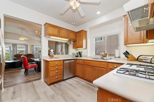 kitchen featuring lofted ceiling, dishwasher, range hood, light hardwood / wood-style flooring, and sink