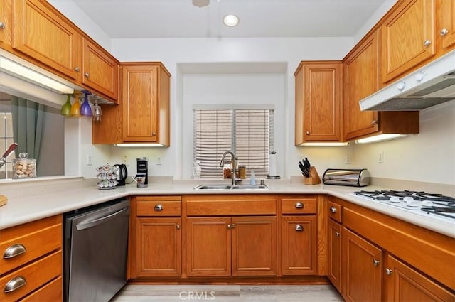 kitchen with dishwasher, a sink, light countertops, under cabinet range hood, and white gas stovetop