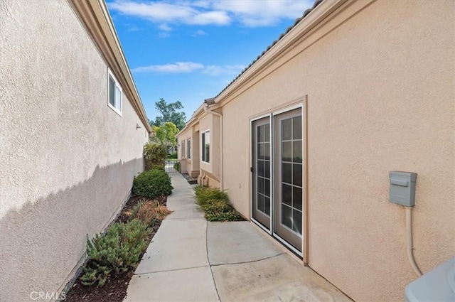 view of side of property featuring a patio and stucco siding
