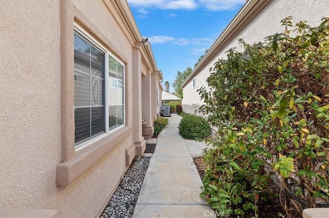 view of side of property featuring cooling unit and stucco siding