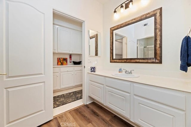 bathroom with hardwood / wood-style floors and vanity