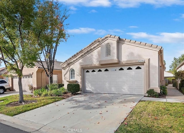 view of front of property with an attached garage, driveway, and stucco siding