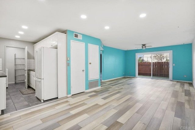 unfurnished living room with ceiling fan and light hardwood / wood-style floors