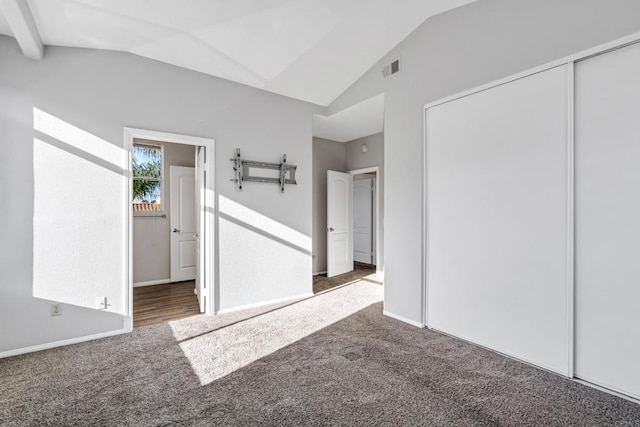 interior space with dark colored carpet and vaulted ceiling