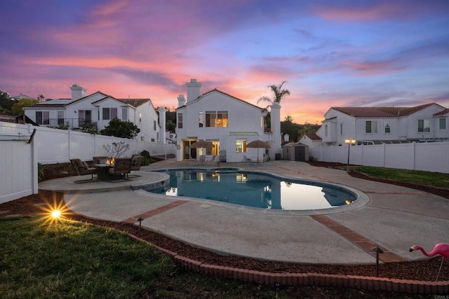 pool at dusk with a patio