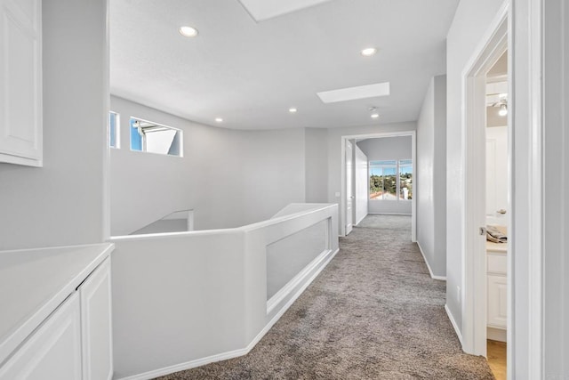 corridor featuring light colored carpet