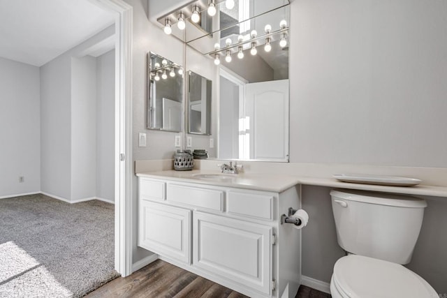 bathroom with wood-type flooring, vanity, and toilet