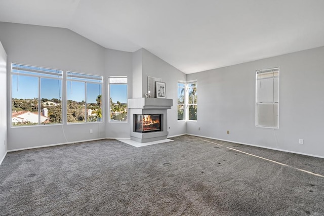 unfurnished living room featuring a multi sided fireplace, lofted ceiling, and carpet flooring