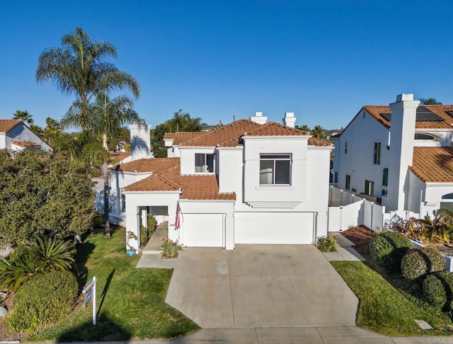 mediterranean / spanish home with stucco siding, fence, a garage, driveway, and a tiled roof