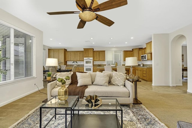 carpeted living room featuring ceiling fan