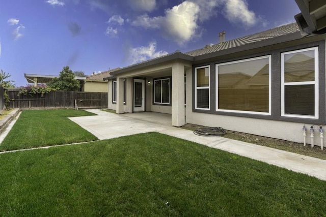 rear view of property with a patio area and a yard