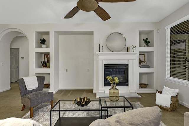 living room with ceiling fan, built in shelves, and carpet