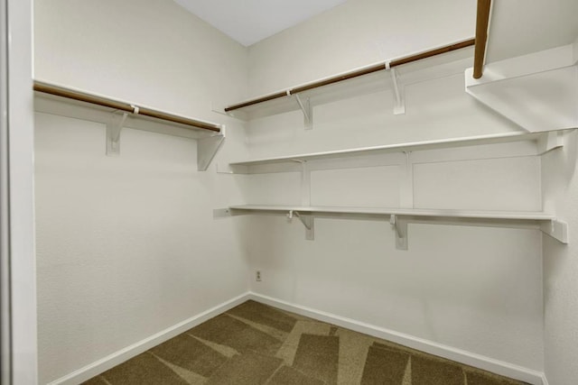 spacious closet featuring dark carpet