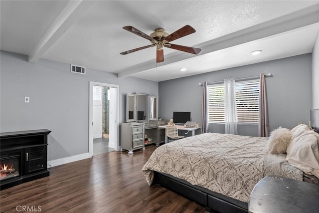 bedroom featuring beamed ceiling, ceiling fan, dark wood-type flooring, and a textured ceiling