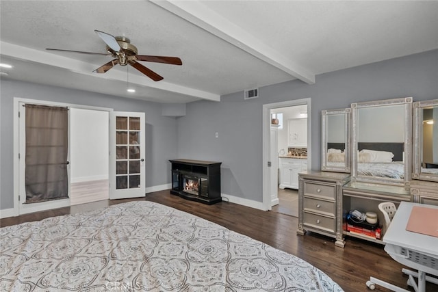 bedroom featuring connected bathroom, beam ceiling, ceiling fan, dark wood-type flooring, and a textured ceiling