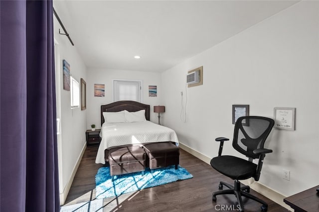 bedroom with a wall mounted air conditioner and dark hardwood / wood-style flooring