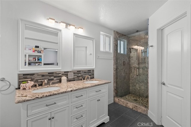 bathroom with walk in shower, a textured ceiling, vanity, tile patterned flooring, and backsplash