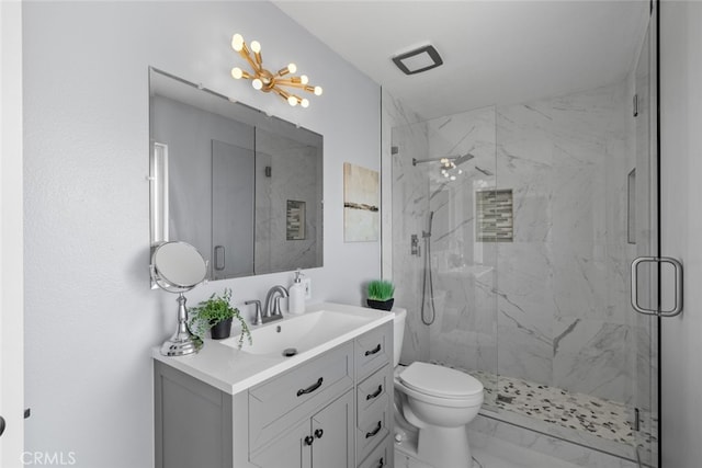 bathroom featuring vanity, toilet, and a shower with door