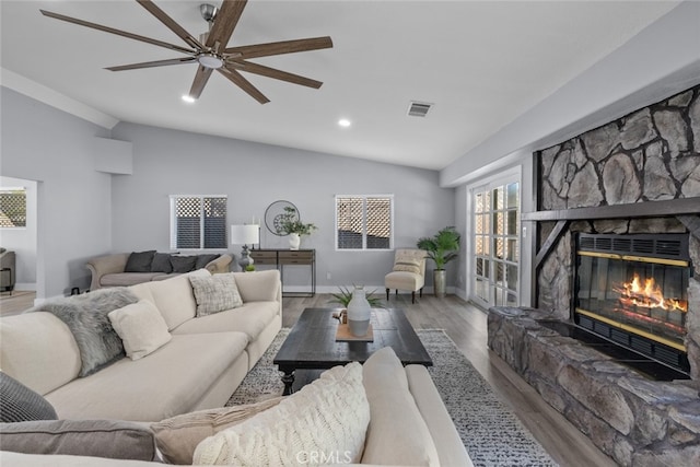 living room with lofted ceiling, ceiling fan, a fireplace, and wood-type flooring