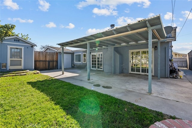 back of property featuring a storage shed, a yard, and a patio area