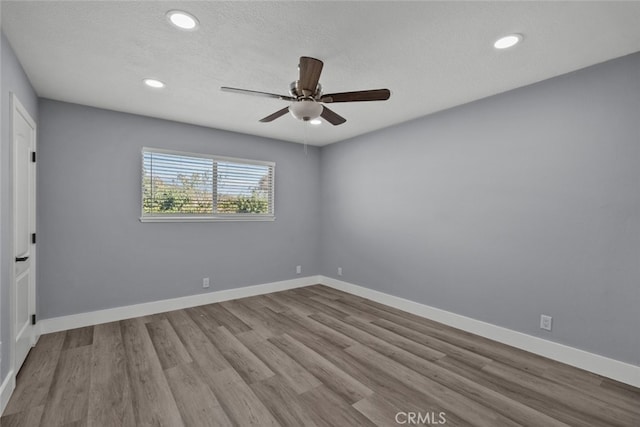 empty room with a textured ceiling, light hardwood / wood-style flooring, and ceiling fan