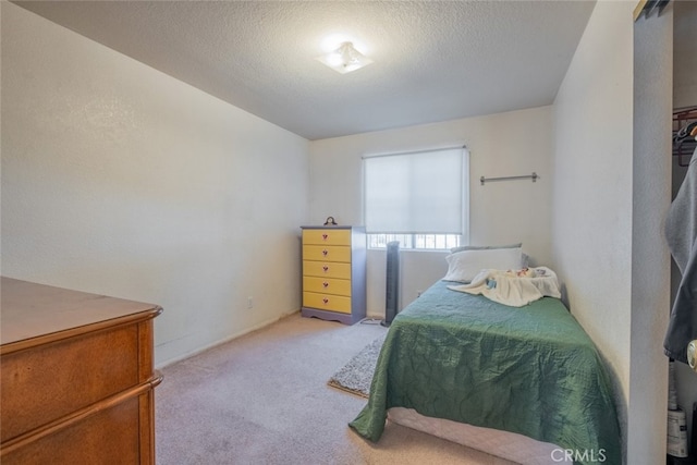 bedroom with a textured ceiling and light carpet