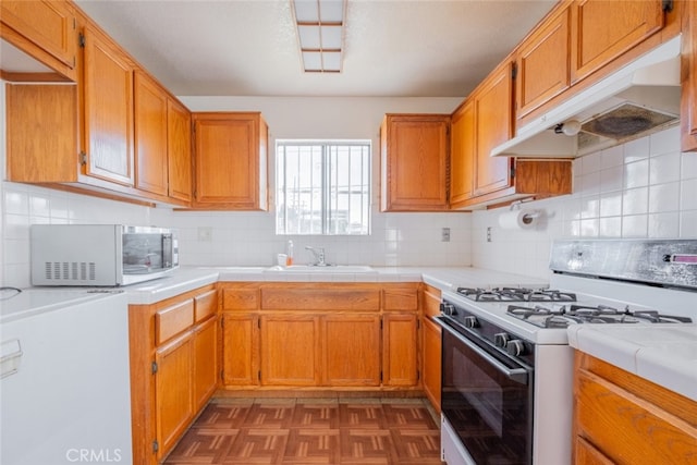 kitchen with white range with gas stovetop, backsplash, sink, and dark parquet floors