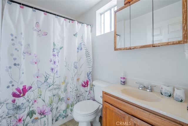 bathroom with toilet, vanity, tile patterned floors, and walk in shower