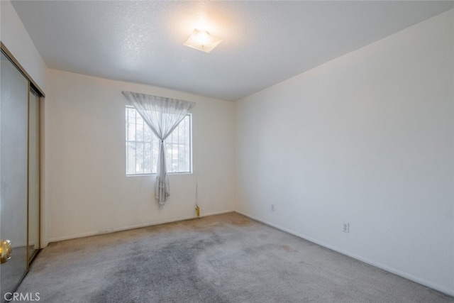 unfurnished room featuring light colored carpet