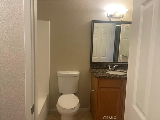 bathroom with toilet, vanity, tile patterned flooring, and a bathtub