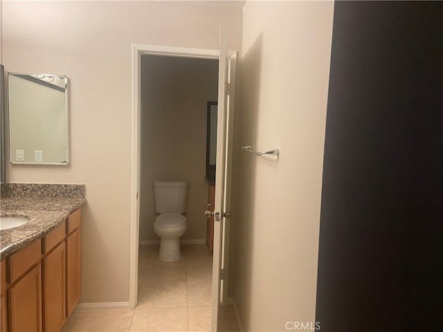 bathroom featuring toilet, vanity, and tile patterned floors