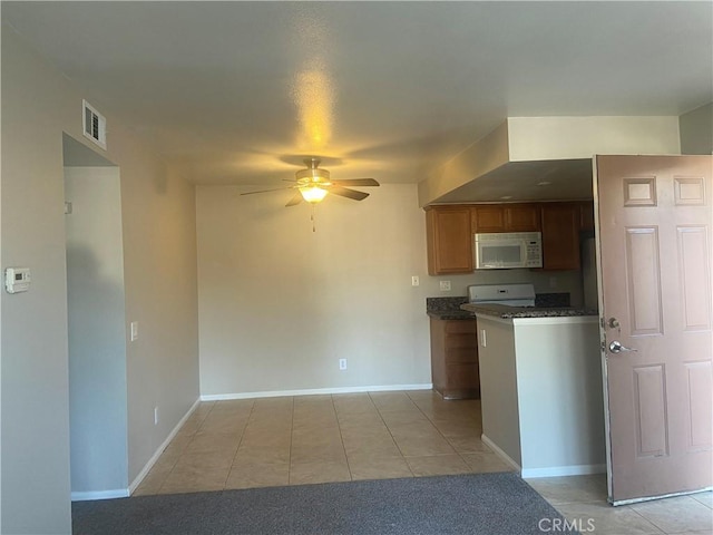 kitchen featuring ceiling fan, light tile patterned floors, and stove