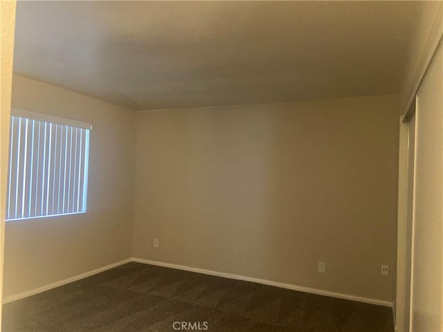 unfurnished room with dark colored carpet