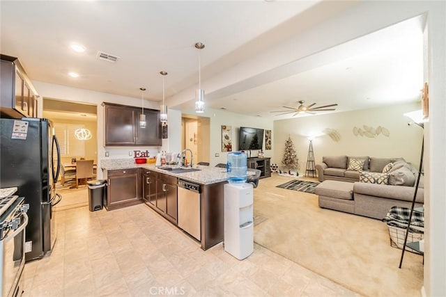 kitchen featuring ceiling fan, decorative light fixtures, sink, light stone countertops, and stainless steel appliances