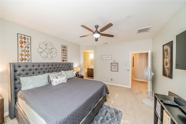 bedroom featuring ceiling fan, light colored carpet, and ensuite bath