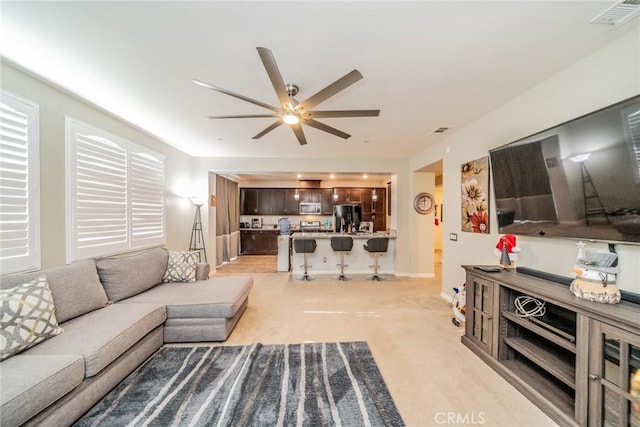 carpeted living room featuring ceiling fan