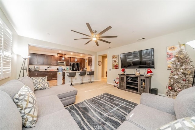 living room with ceiling fan and light colored carpet