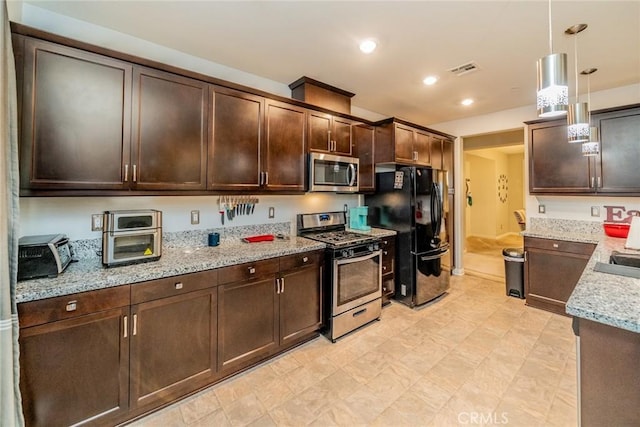 kitchen featuring decorative light fixtures, sink, dark brown cabinetry, appliances with stainless steel finishes, and light stone counters