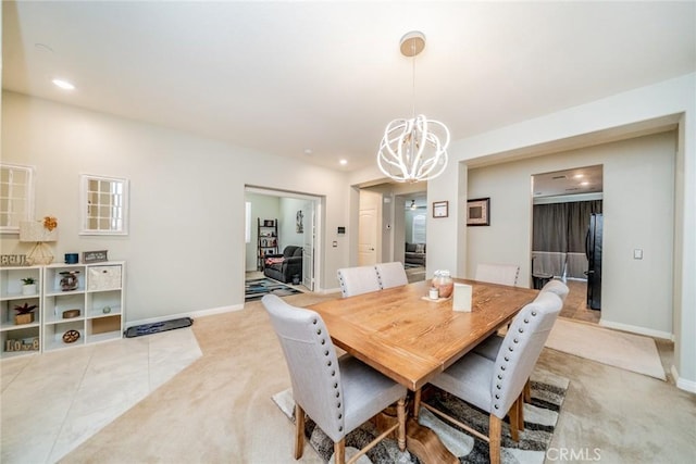 carpeted dining room featuring an inviting chandelier