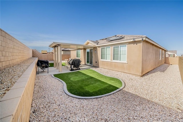 back of house featuring solar panels and a patio