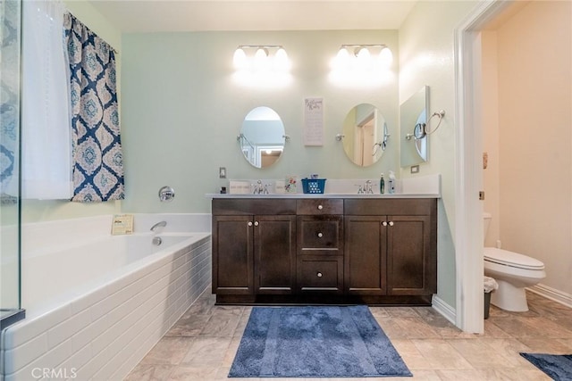 bathroom featuring toilet, tiled bath, and vanity