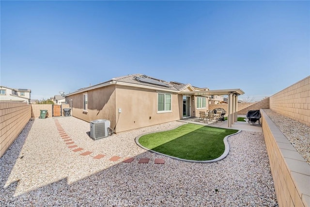 back of property featuring central AC unit, a patio area, and solar panels