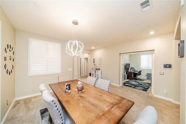 dining room featuring light colored carpet and a chandelier