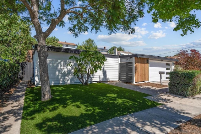 view of front of house with a front lawn, a garage, and an outbuilding