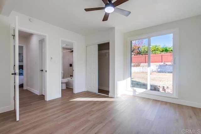 unfurnished bedroom featuring ceiling fan, a closet, light hardwood / wood-style flooring, and ensuite bath