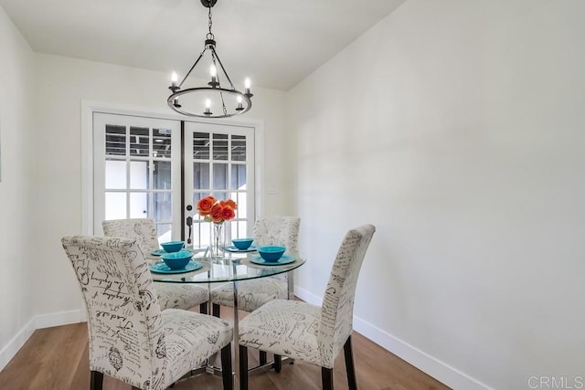 dining room with wood-type flooring and a notable chandelier