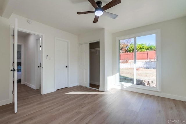 unfurnished bedroom featuring ceiling fan, light wood-type flooring, and a closet