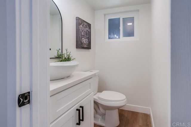 bathroom featuring toilet, wood-type flooring, and vanity